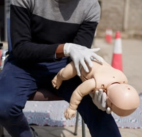 Infant choking first aid Trainer demonstrating infant choking first aid on a manikin