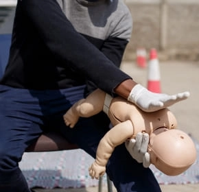 Infant back blows Trainer positioning an infant manikin for back blows